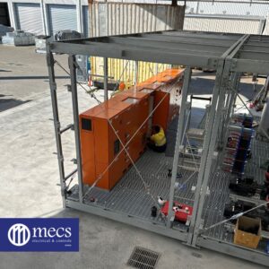 MECS electrical mechanic performing maintenance on a large orange BMS Controls system installed in an industrial setting