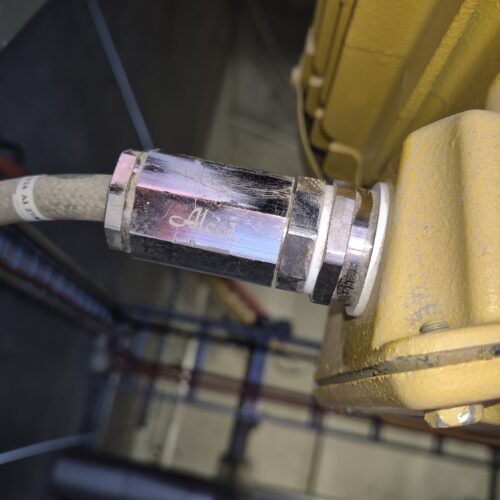 A yellow hose connected to a yellow machine in Perth cold storage plant room, part of MECS hazardous certification ensuring safety compliance
