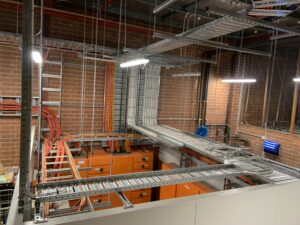 Power Monitoring setup in a room with orange and yellow wires, part of the Coles Full Switchboard Refresh project