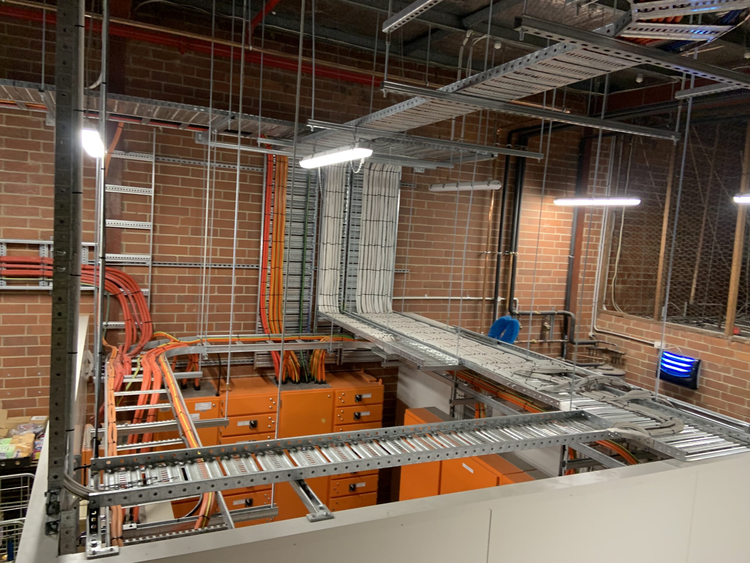Power Monitoring setup in a room with orange and yellow wires, part of the Coles Full Switchboard Refresh project