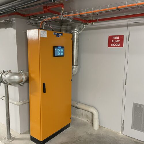 An orange electrical control panel installed at Rivean Apartments for carbon monoxide safety control