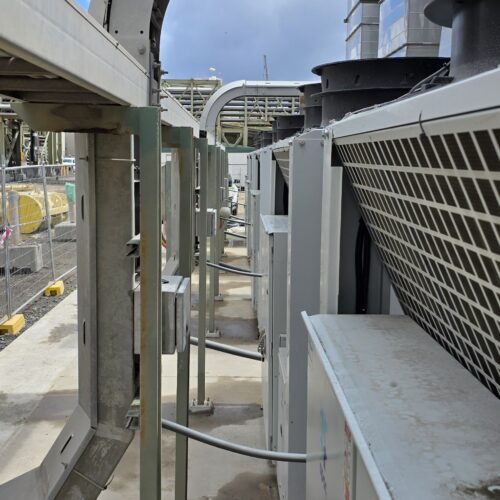 Multiple air conditioning units on rooftop connected to HVAC control system for efficient building climate regulation
