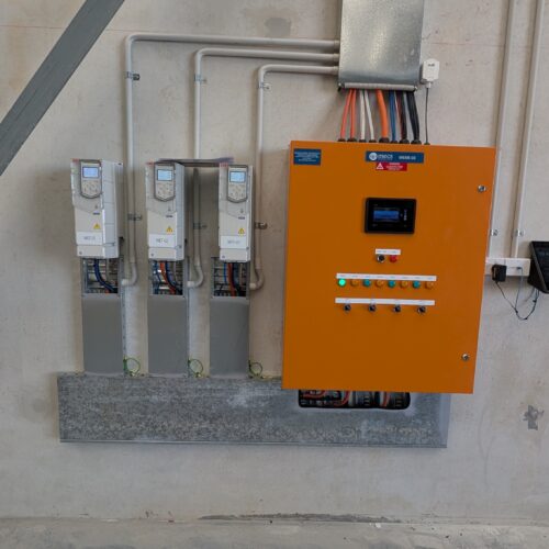 Wall-mounted electrical control panel with two connected wires, installed by electrical mechanic for industrial control operations