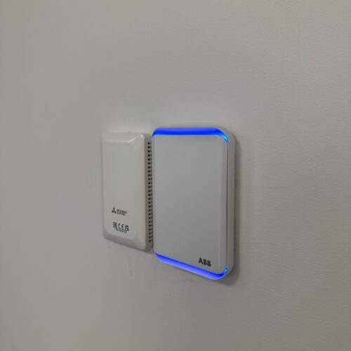 Two blue light switches mounted on white wall showing electrical control points installed by MECS electrical mechanic in a room setup