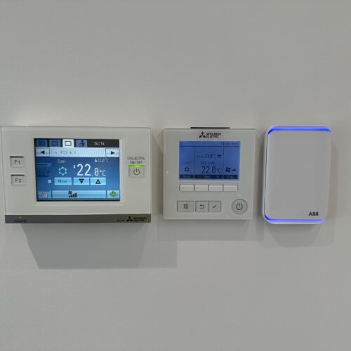 A white wall featuring a digital thermostat, indicating temperature control installed by MECS electrical mechanoc