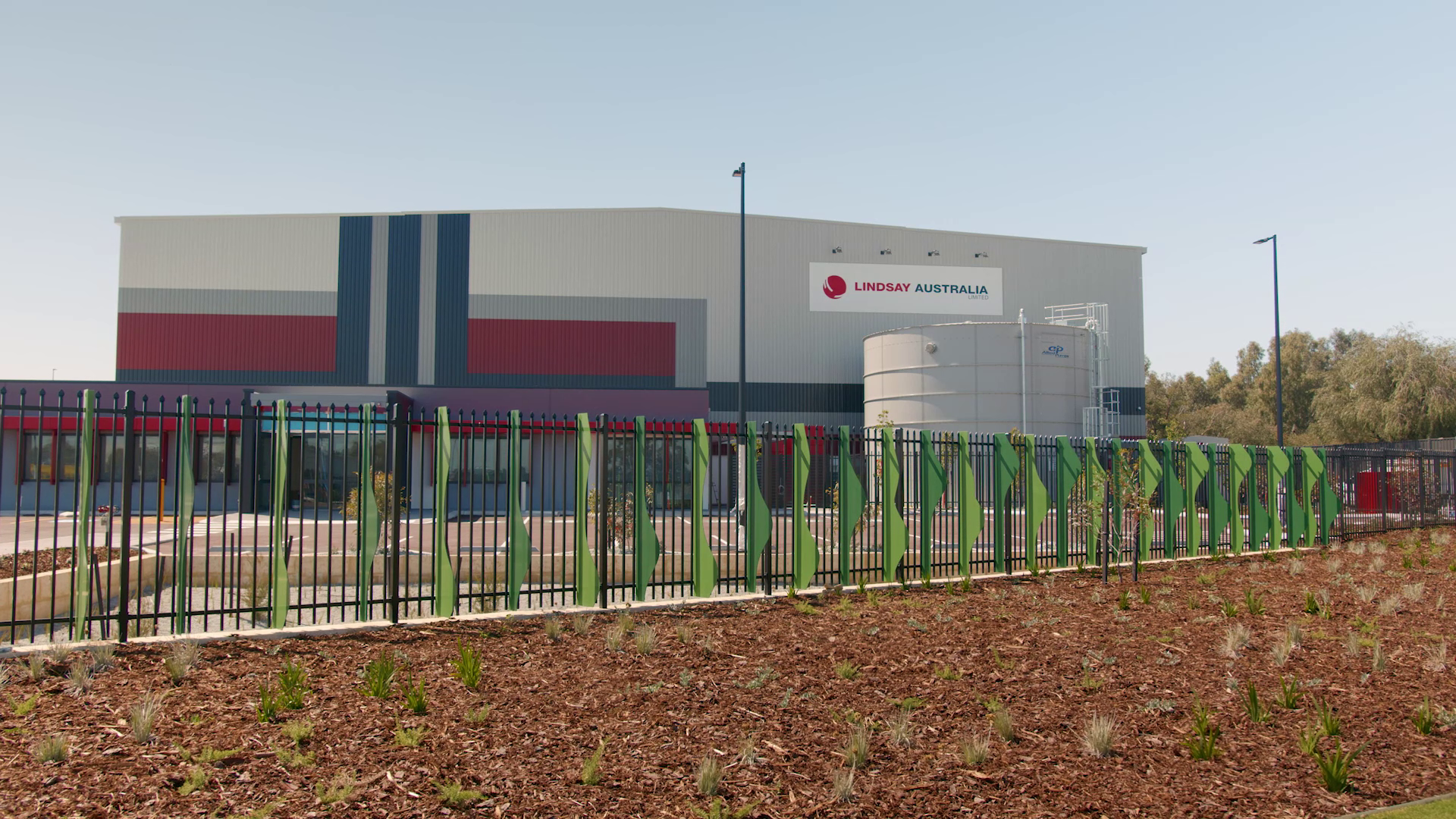Large building with green fencing where MECS installed HVAC control system for climate management solution